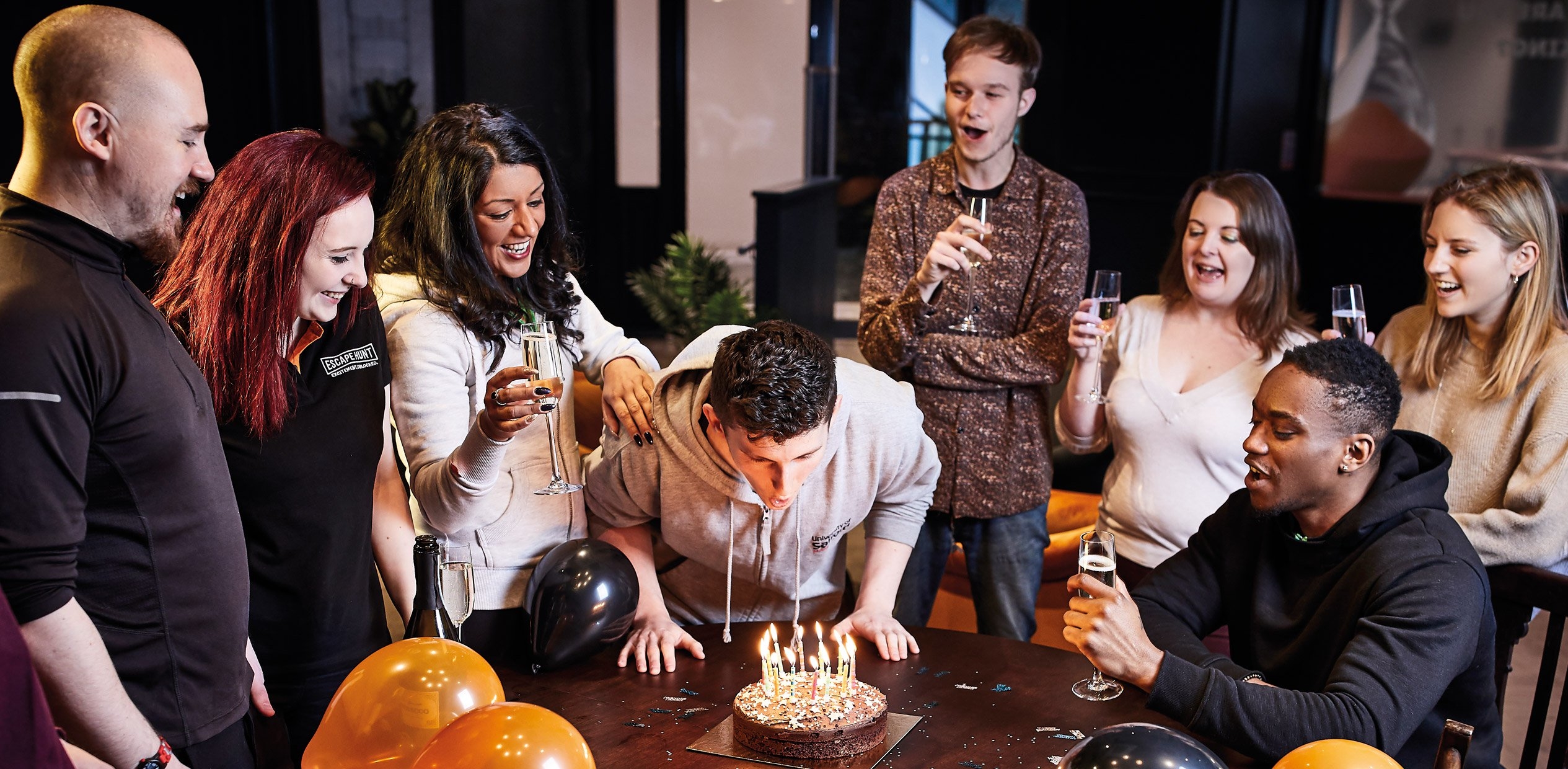 The birthday boy blows the candle accompanied by his team